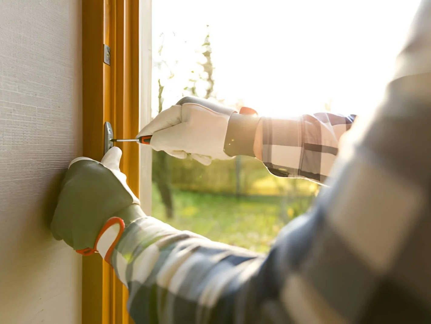 Handyman fixing the window with screwdriver