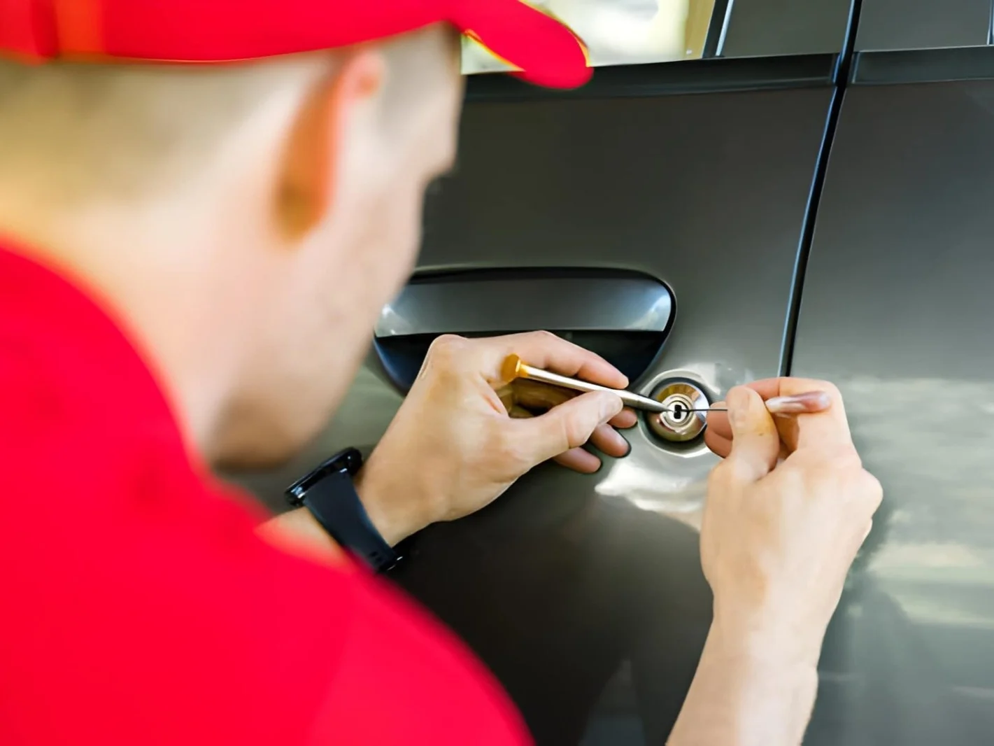 Locksmith opening car door with lockpicker