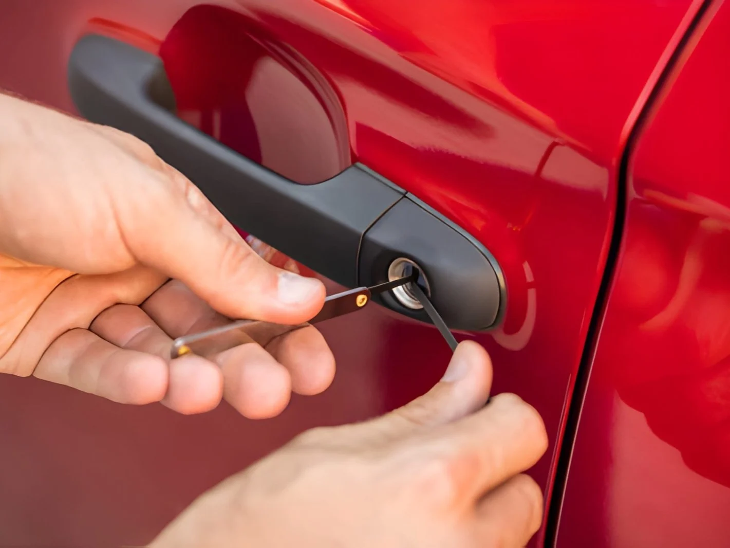 Person opening car door with lockpicker