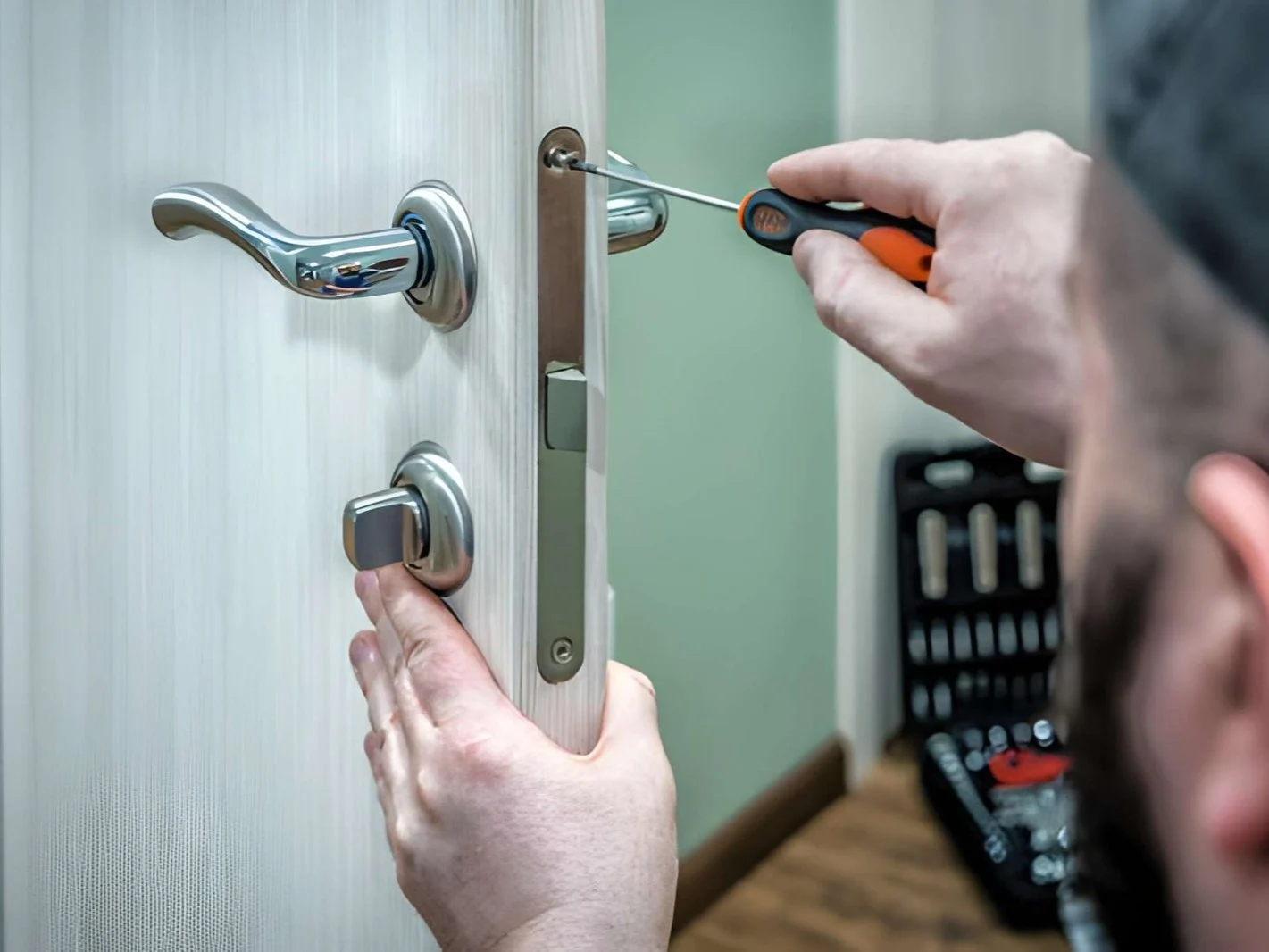 Professional locksmith worker installing the part of lock